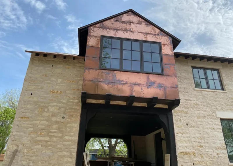 Copper metal panel facade on a stone building for Roof Repair in Lochmoor Waterway Estates