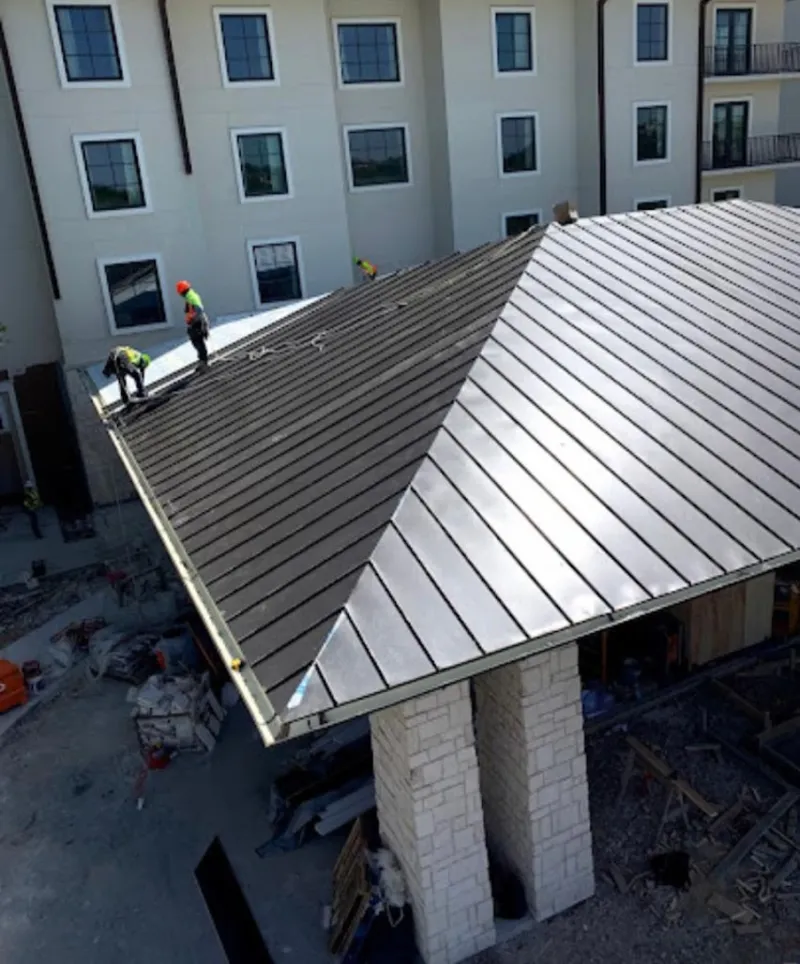Crew installing standing seam metal roof panels on a commercial project in Lochmoor Waterway Estates